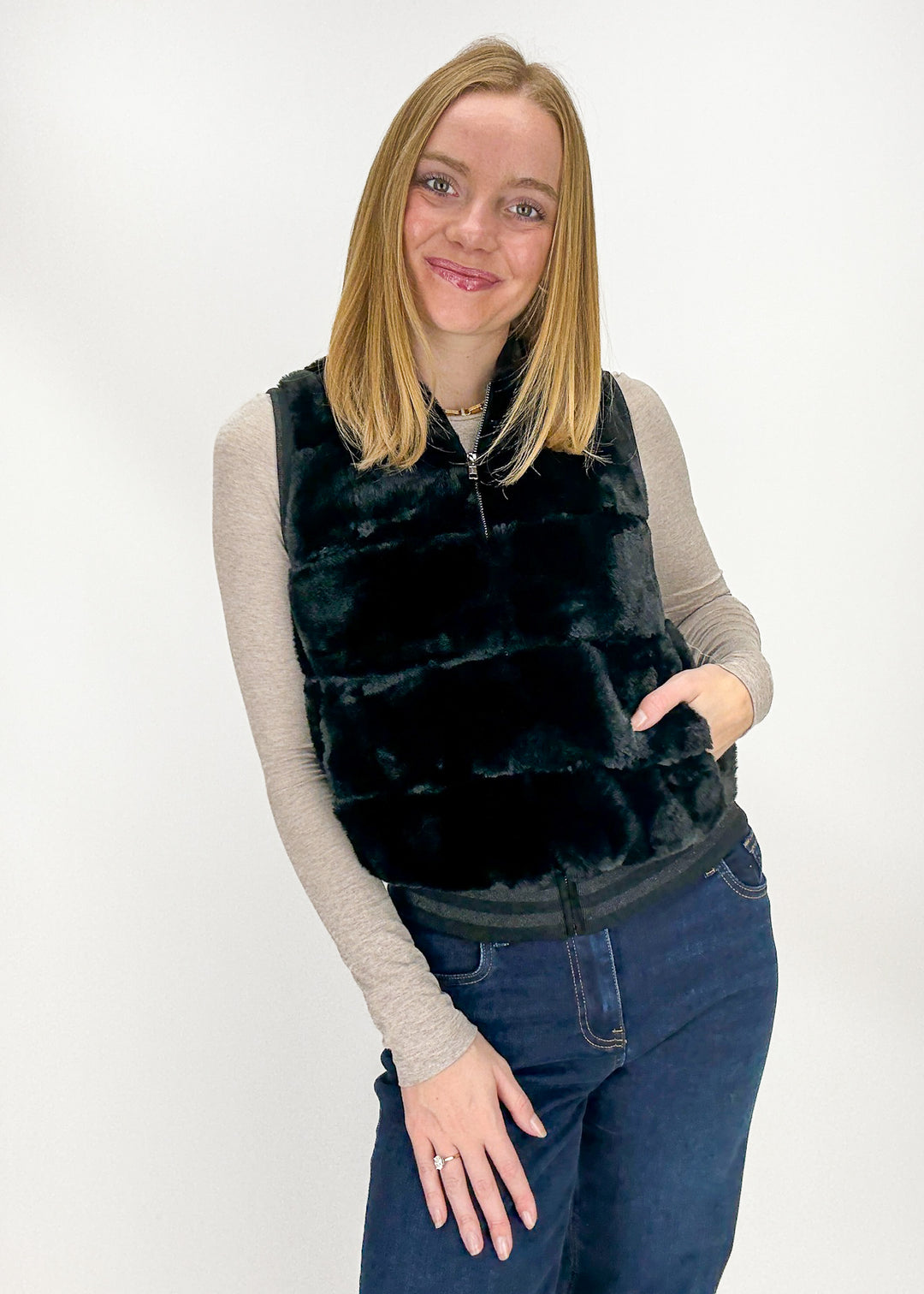 Woman wearing a black faux fur vest 