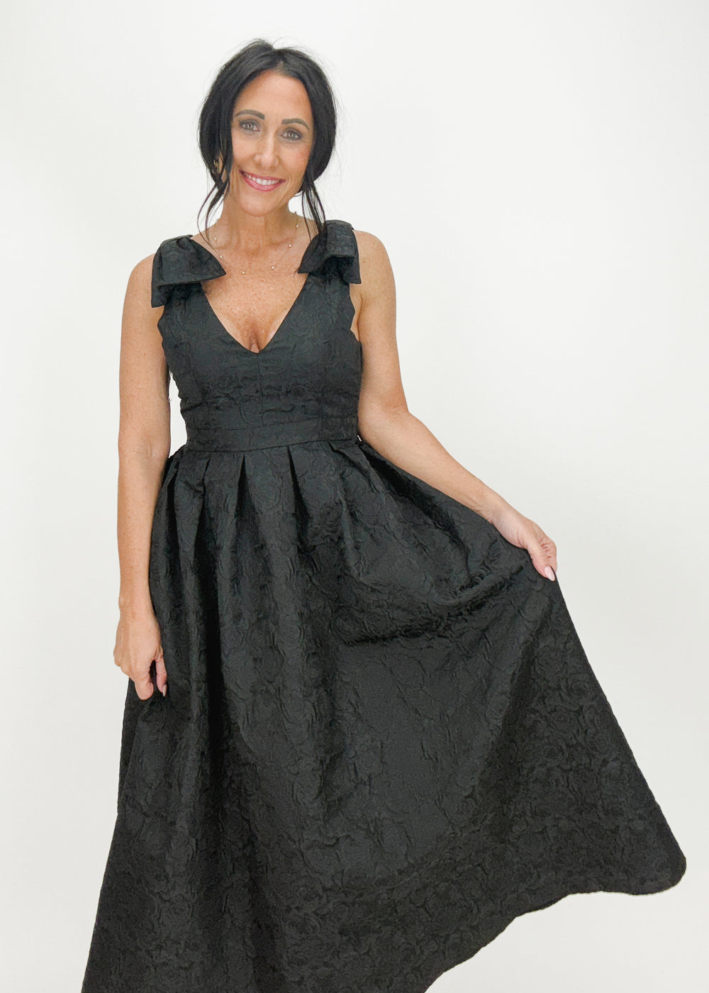 woman wearing black v-neck jacquard midi dress with bow straps