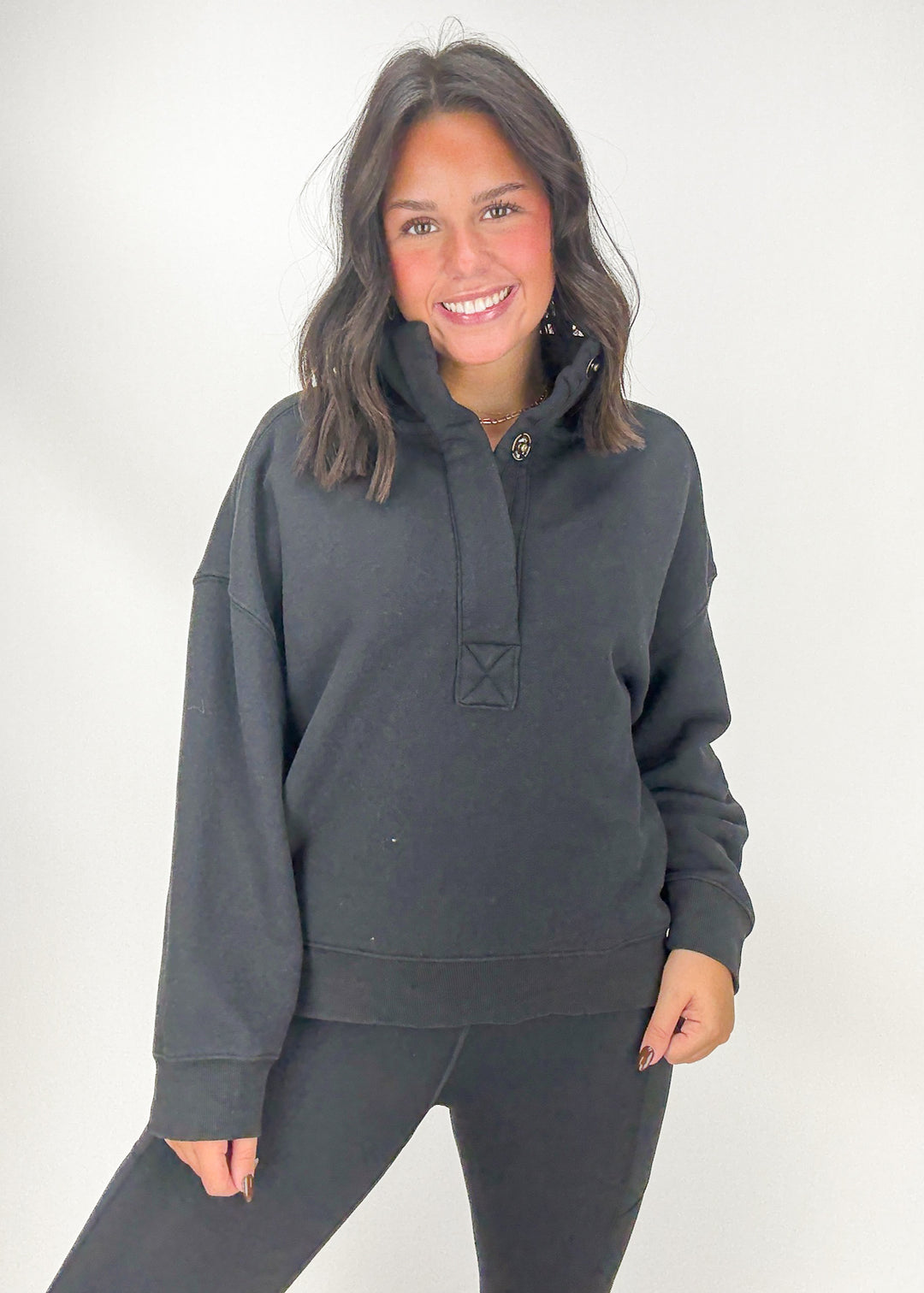 Woman wearing a dark gray hoodie and pants 