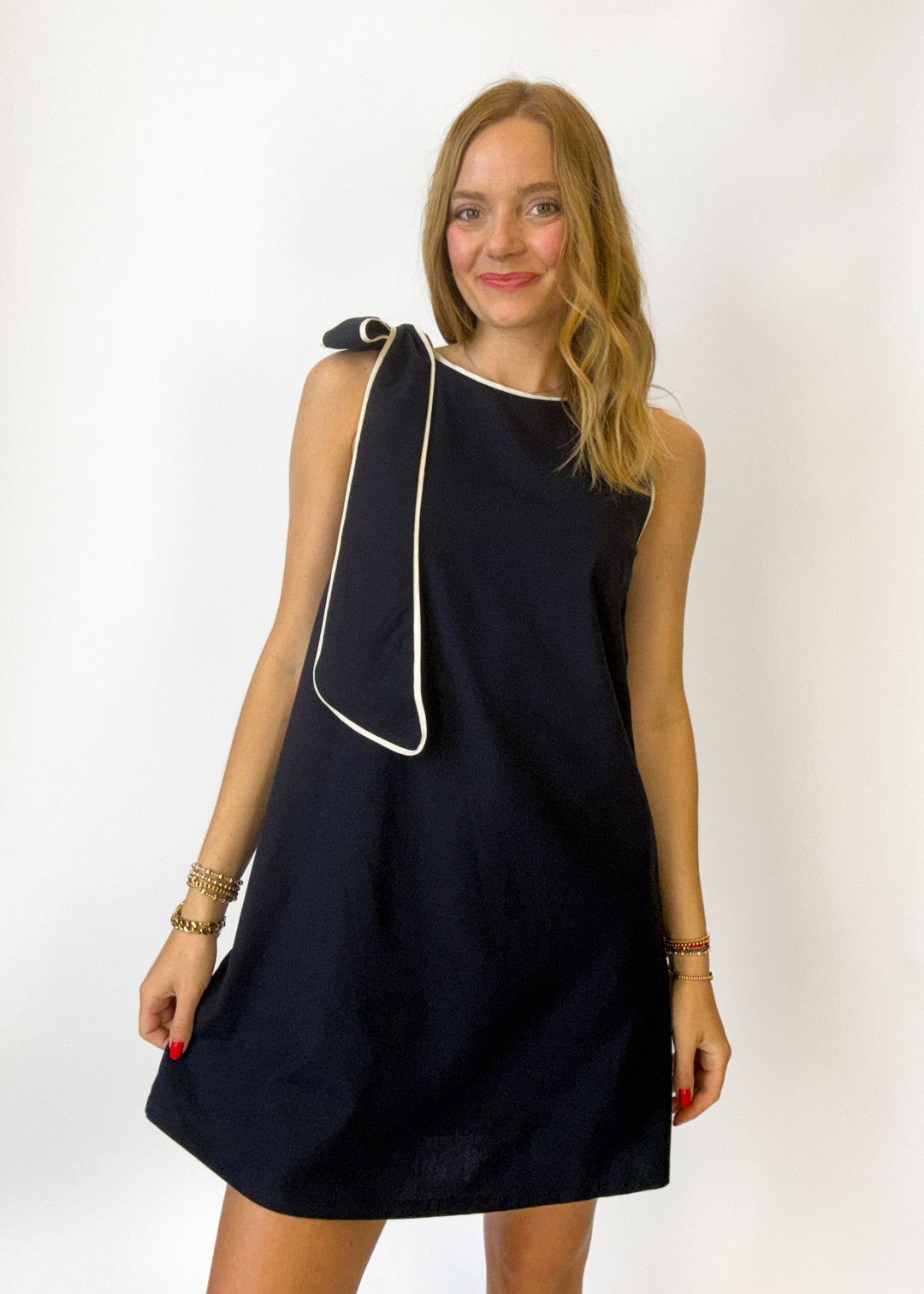 Woman wearing a black dress with white trim on a white background