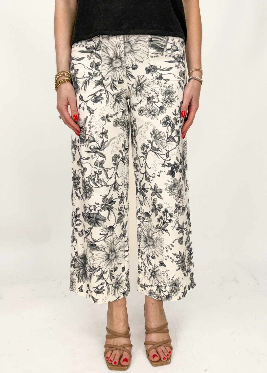 Person wearing floral-patterned pants on a white background