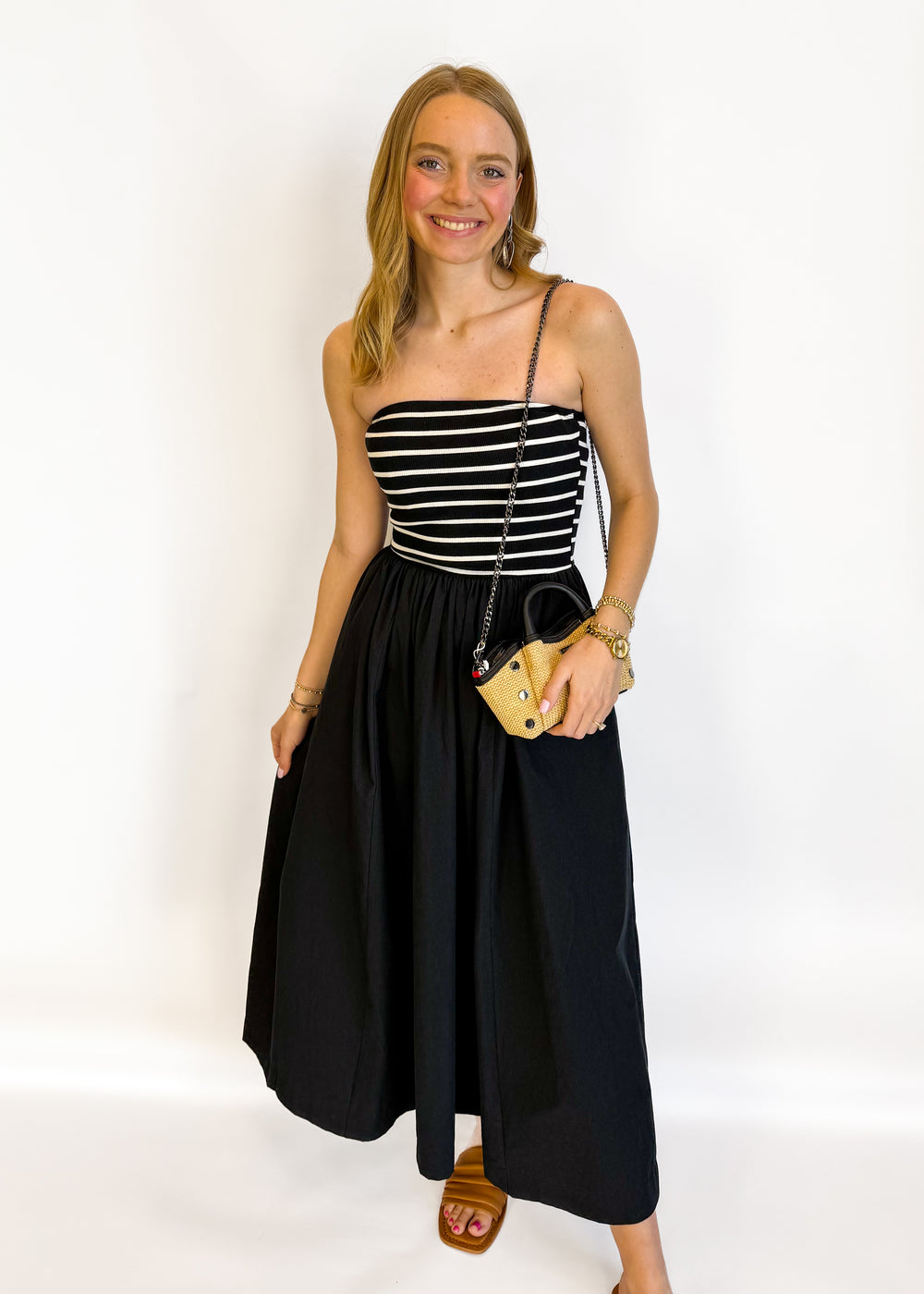 Woman wearing a black and white striped dress with a black skirt on a white background