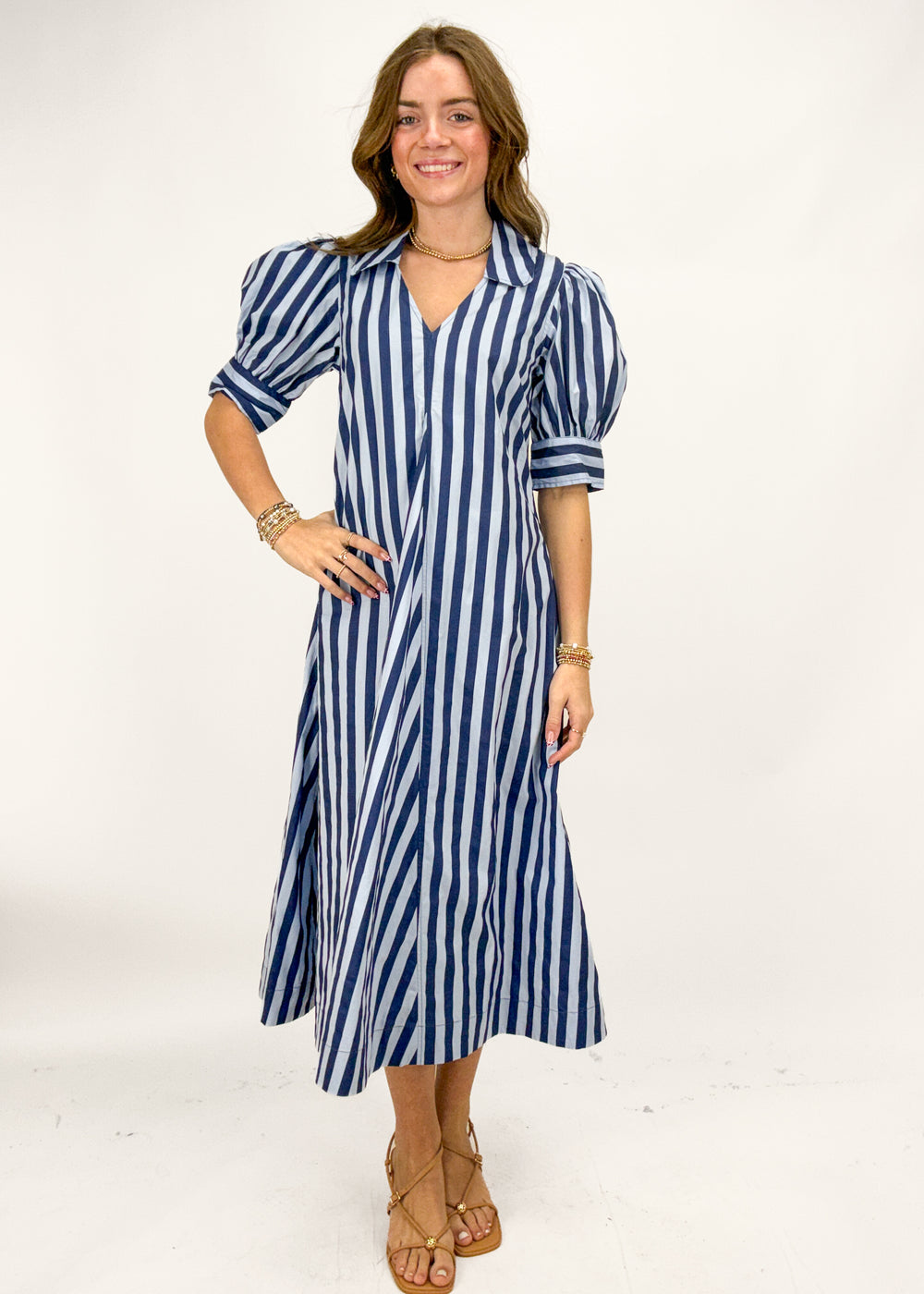 Woman wearing a blue striped dress on a white background