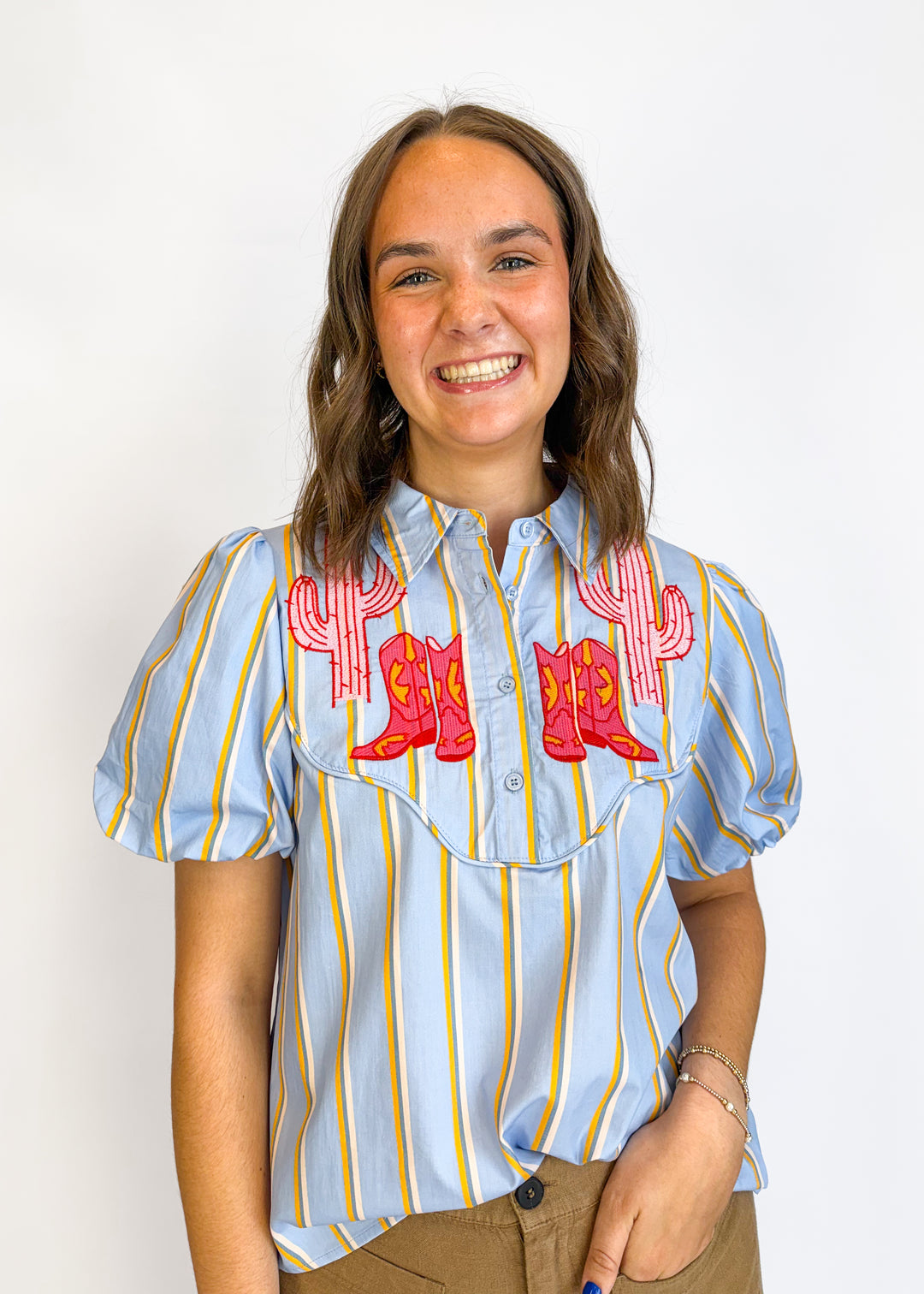 Person wearing a light blue striped shirt with red graphics on a white background