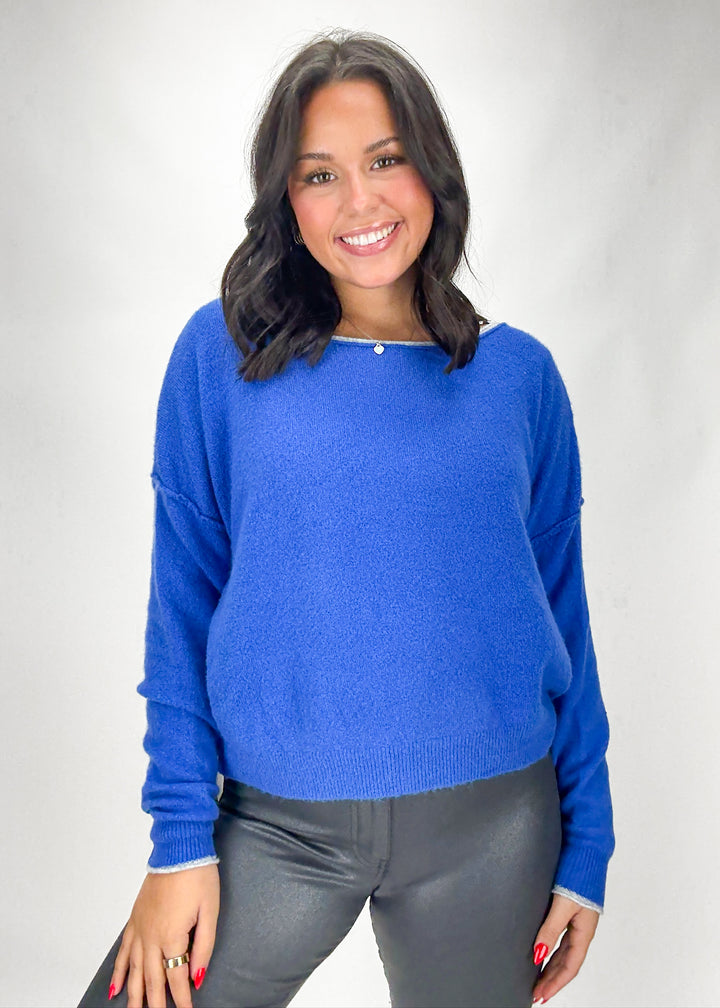 Woman wearing a blue sweater against a white background