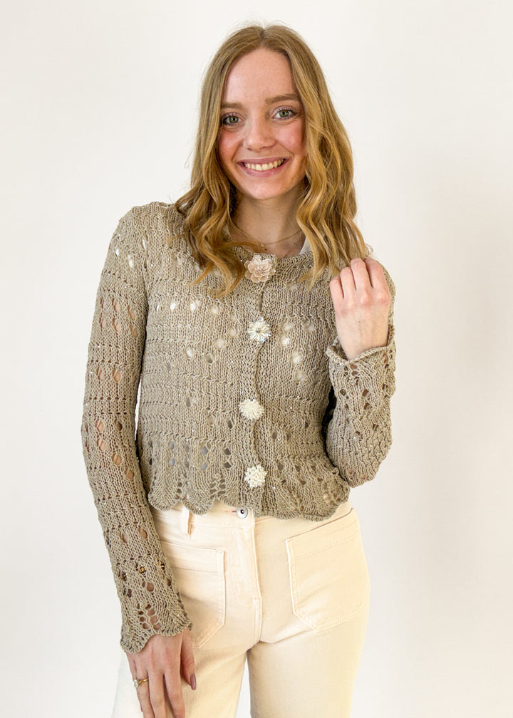 Woman wearing a textured sweater with floral patterns on a white background