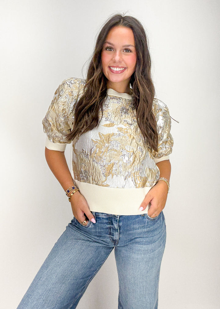 Woman wearing a patterned top and jeans 