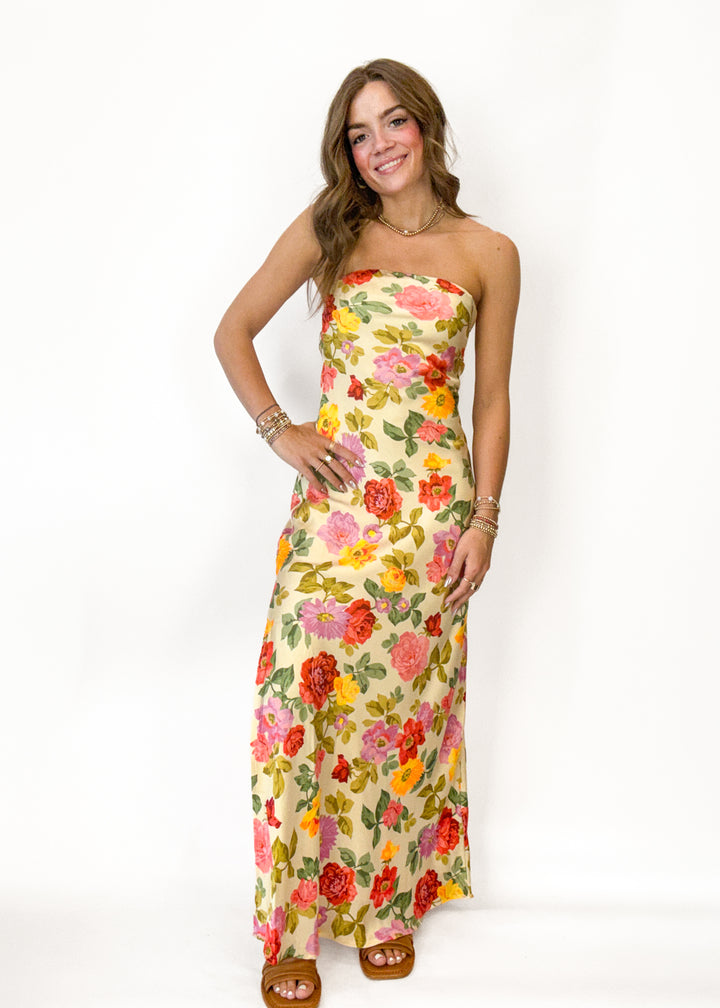 Woman wearing a floral strapless dress on a white background