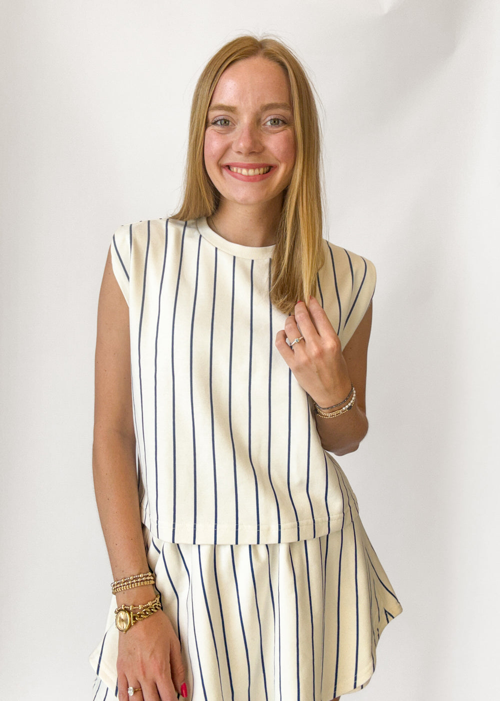 Woman wearing a striped outfit with a plain background
