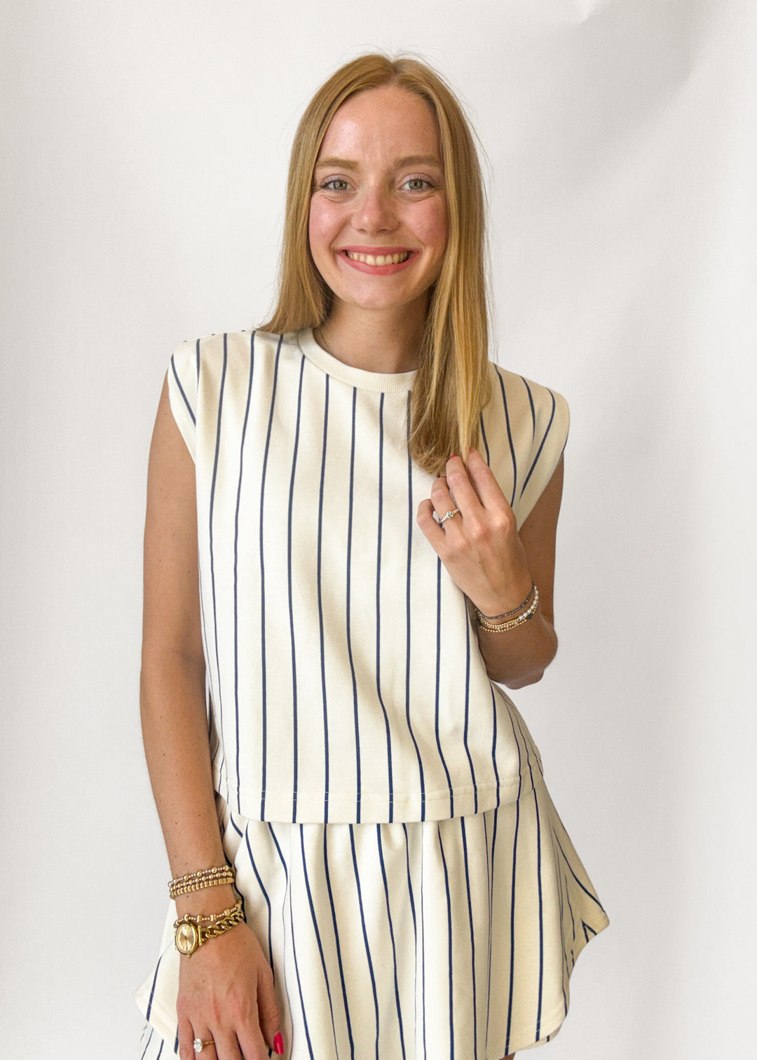 Woman wearing a striped outfit with a plain background