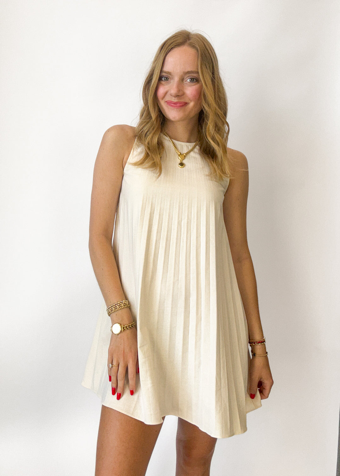 Woman wearing a beige sleeveless dress against a white background