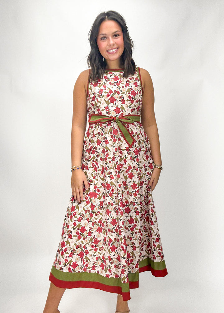 Woman wearing a floral dress with a belt on a white background