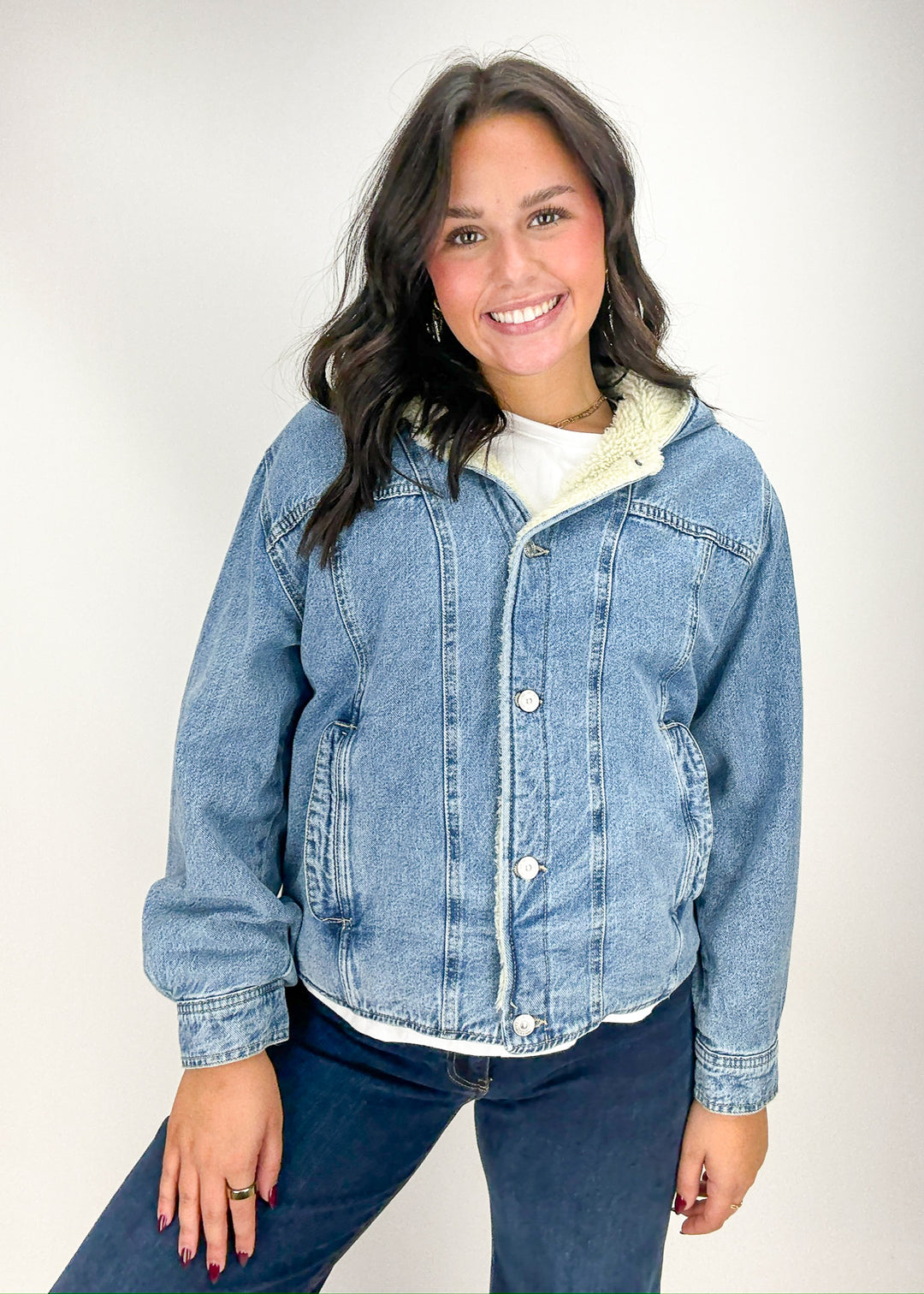 Woman wearing a denim jacket with a white shirt underneath 