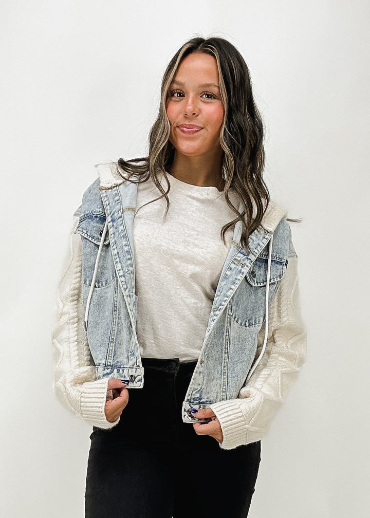 women's light wash denim jacket with white cable knit sleeves and hood