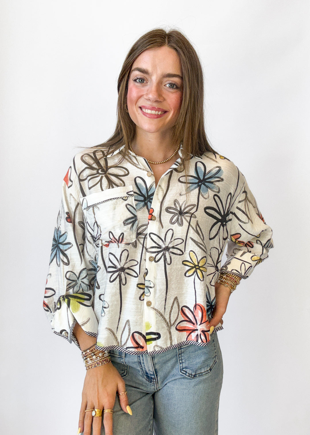 Woman wearing a floral patterned shirt with a plain background