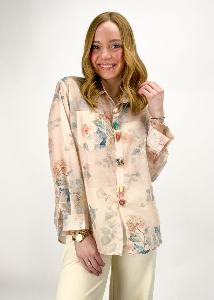 Woman wearing a floral blouse with a plain background