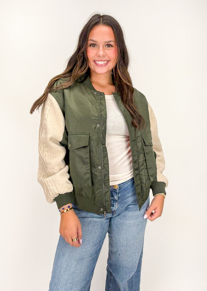 Woman wearing a green and beige jacket 