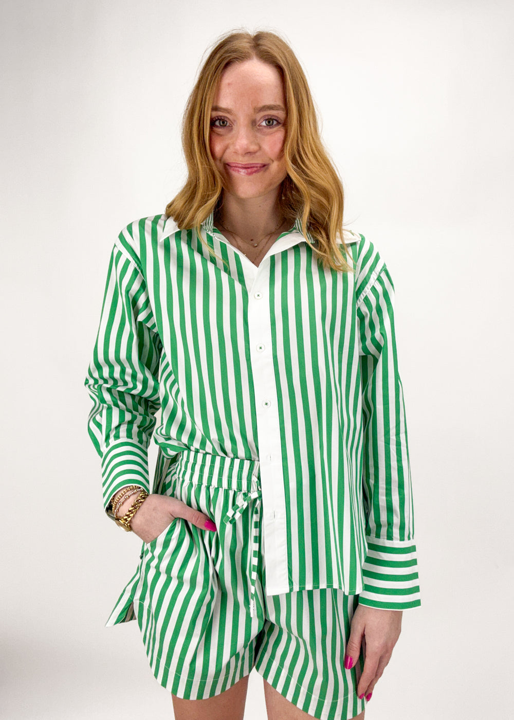 Woman wearing a green and white striped shirt and shorts set on a white background