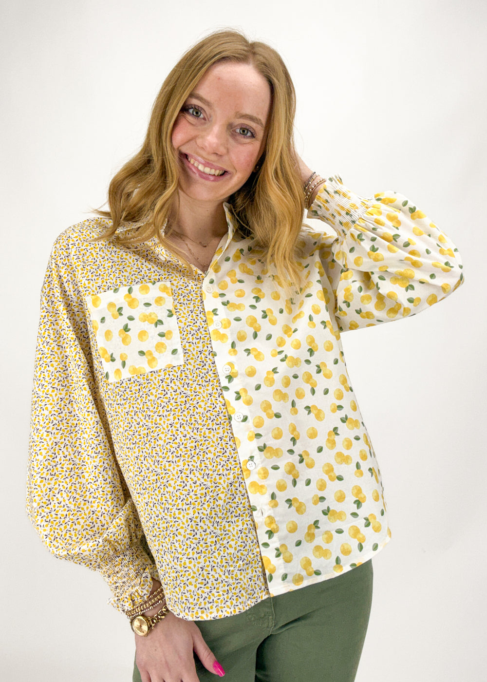 Woman wearing a yellow floral blouse with a white background