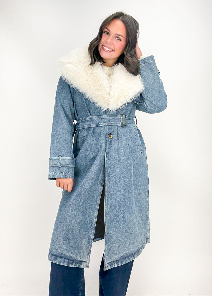 Woman wearing a denim coat with white fur trim 