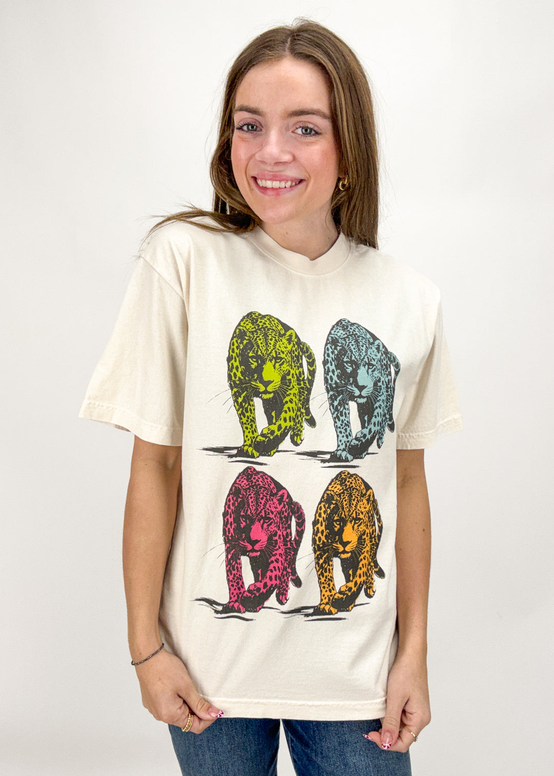 Person wearing a cream t-shirt with colorful elephant design on a white background