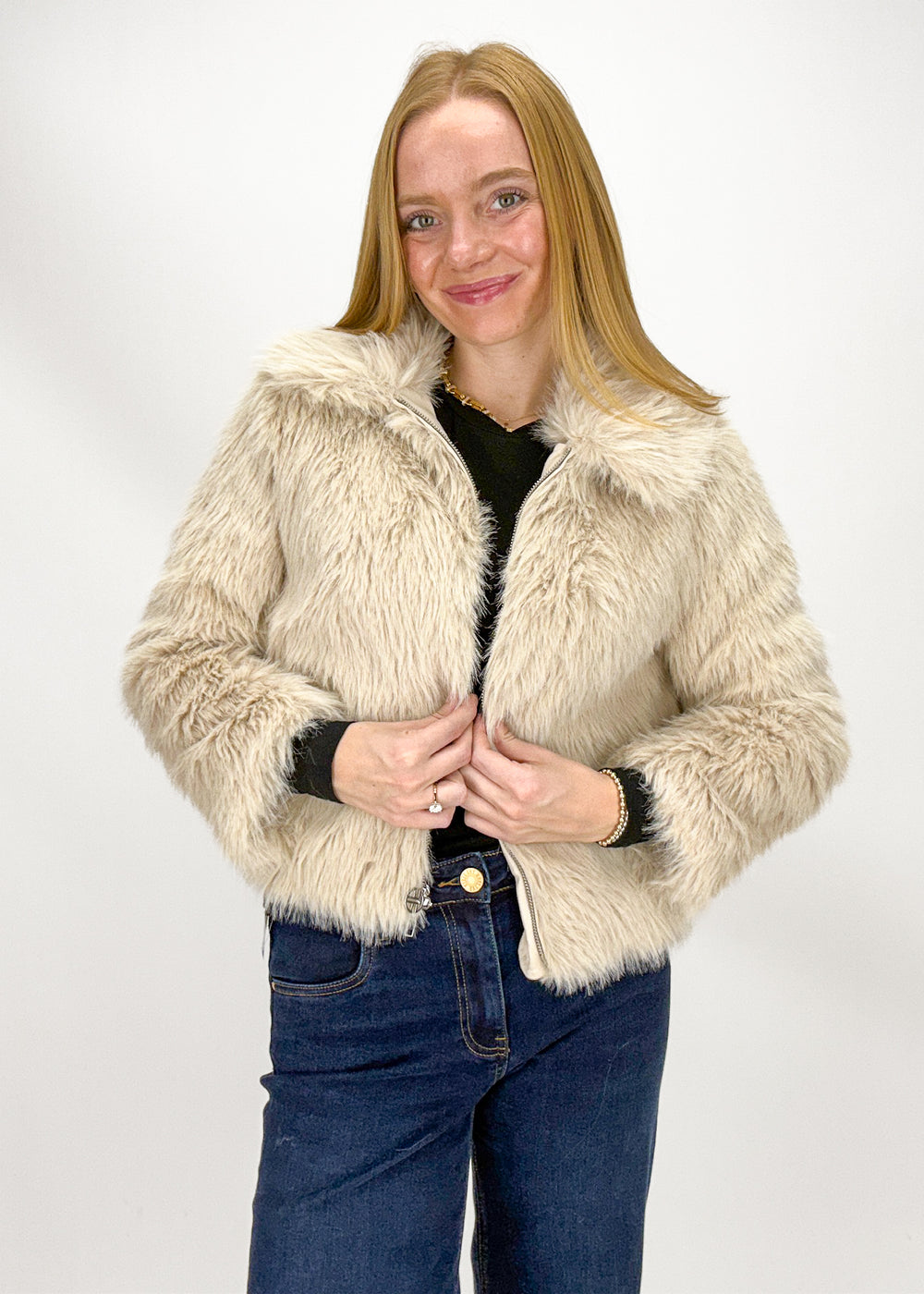 Woman wearing a beige faux fur jacket 