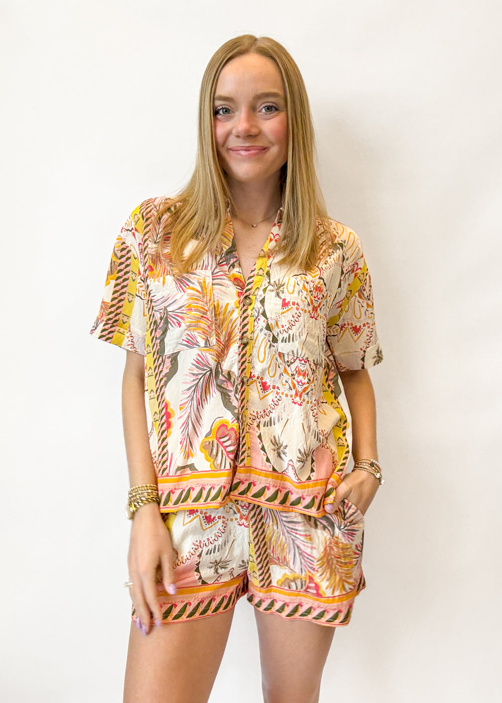 Woman wearing a floral patterned outfit against a white background