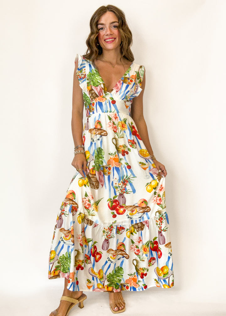 woman wearing a cream maxi dress with pinic print