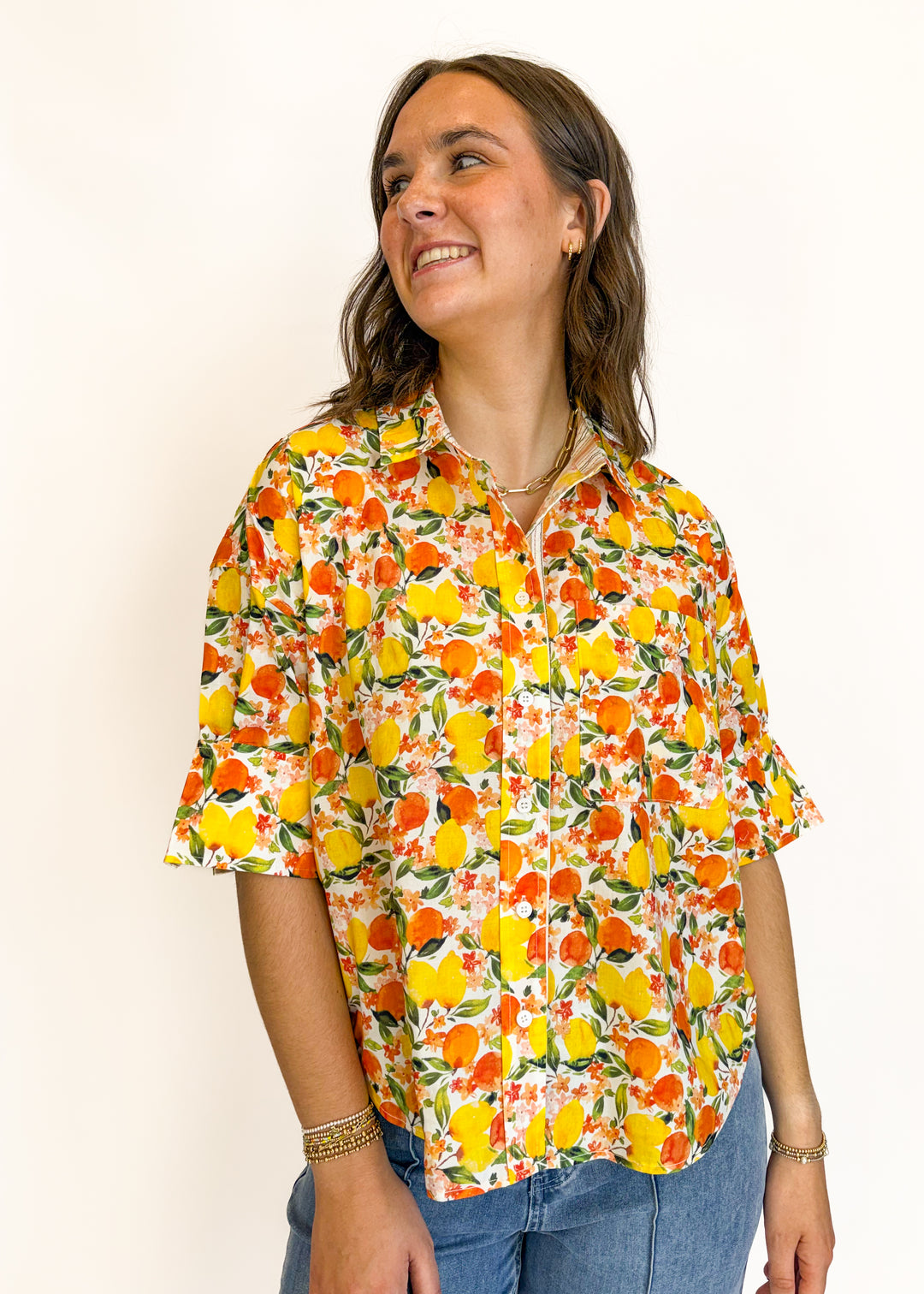 Woman wearing a colorful floral blouse against a plain background